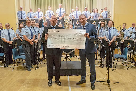 Chris Webb from the UK Police Memorial receiving a cheque from Surrey Police Band Musical Director Graham Atterbury.
